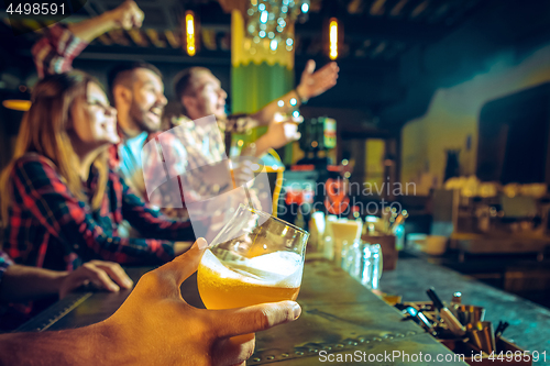 Image of Sport, people, leisure, friendship and entertainment concept - happy football fans or male friends drinking beer and celebrating victory at bar or pub