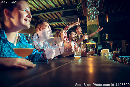 Image of Sport, people, leisure, friendship and entertainment concept - happy football fans or male friends drinking beer and celebrating victory at bar or pub