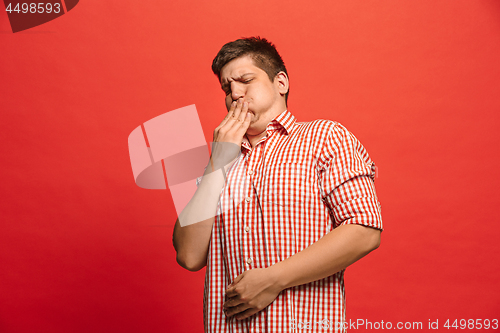 Image of Let me think. Doubtful pensive man with thoughtful expression making choice against red background