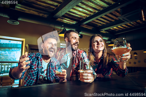 Image of Sport, people, leisure, friendship and entertainment concept - happy football fans or male friends drinking beer and celebrating victory at bar or pub