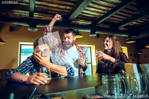 Image of Sport, people, leisure, friendship and entertainment concept - happy football fans or male friends drinking beer and celebrating victory at bar or pub