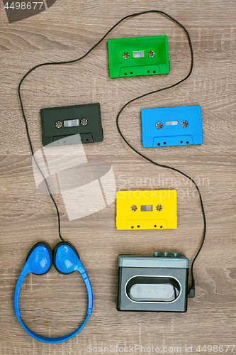 Image of Vintage walkman, colorful cassetes and headphones on the wooden background