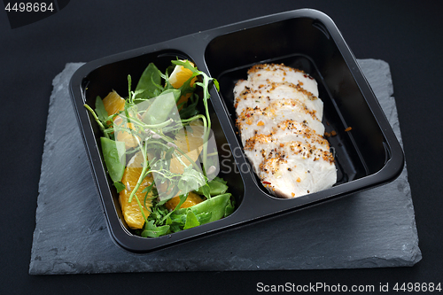 Image of Poultry fillet on a salad with sugar peas and oranges. Balanced box diet, dinner dish.