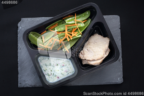 Image of Lunch. Low-cost, balanced diet. Cooked meat on a sweet pea salad served with white yoghurt sauce.