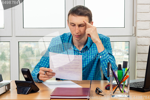 Image of An office specialist reads the document carefully