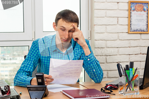 Image of The office specialist reads the document carefully and thoughtfully