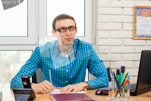 Image of An office worker looks at the visitor with a thoughtful look