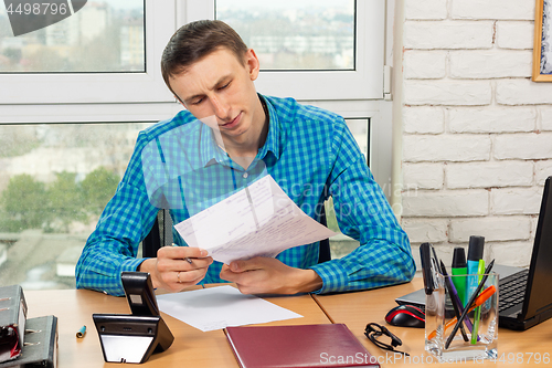 Image of The supervisor carefully reads the visitor\'s application