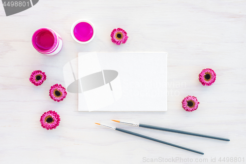 Image of Bright pink acrylic paint and blank canvas