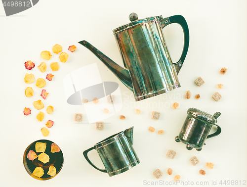 Image of Vintage tea set and cup of tea with rose petals