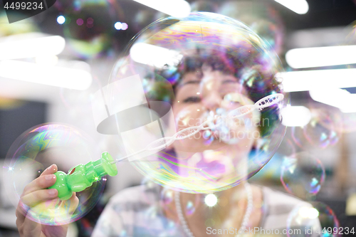 Image of software developer having fun while making soap bubble