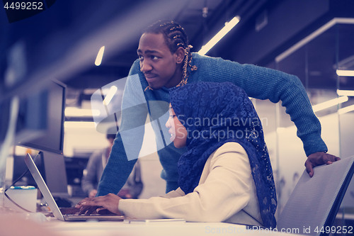 Image of young black muslim female software developer at work