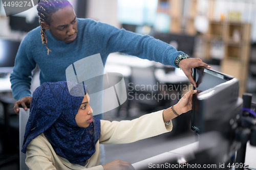 Image of young black muslim female software developer at work