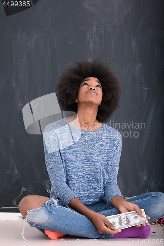 Image of black woman holding money on gray background