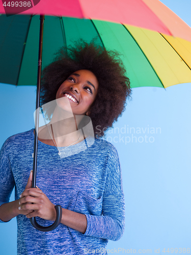 Image of beautiful black woman holding a colorful umbrella