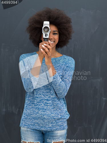 Image of african american woman using a retro video camera