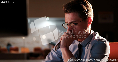 Image of man working on computer in dark office