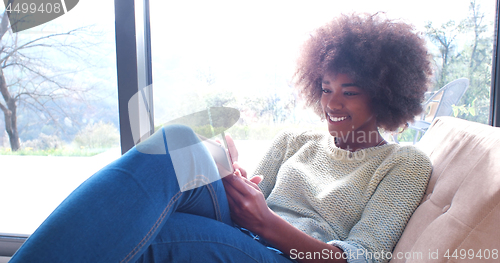 Image of african american woman at home using digital tablet