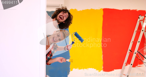 Image of portrait of a couple painting interior wall