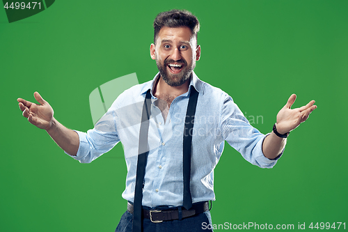 Image of The happy business man standing and smiling against green background.