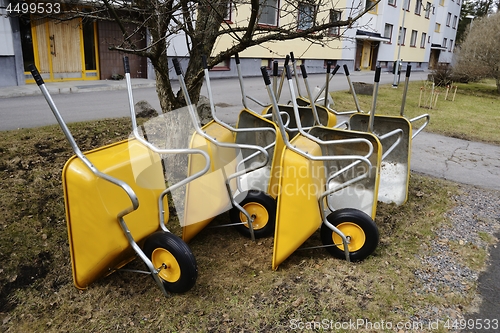 Image of lot of empty new garden wheelbarrows in the yard