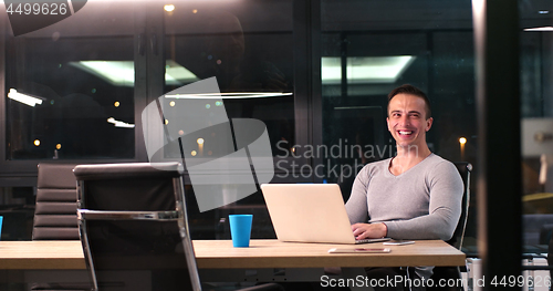 Image of man working on laptop in dark office