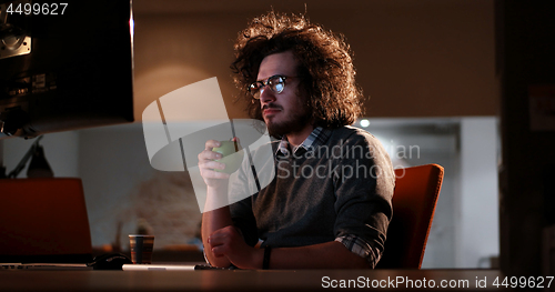 Image of man working on computer in dark office