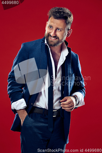 Image of The happy business man standing and smiling against red background.