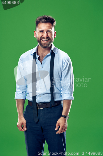 Image of The happy business man standing and smiling against green background.