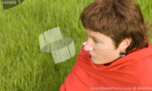 Image of  redhead woman sitting on the grass