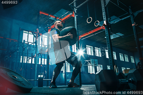 Image of Fit young man lifting barbells working out in a gym