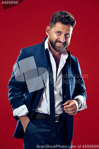 Image of The happy business man standing and smiling against red background.