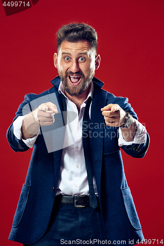 Image of The happy business man point you and want you, half length closeup portrait on red background.