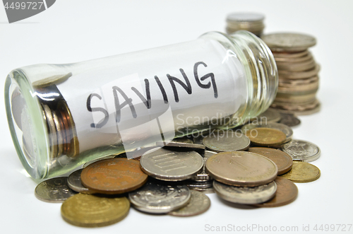 Image of Saving lable in a glass jar with coins spilling out