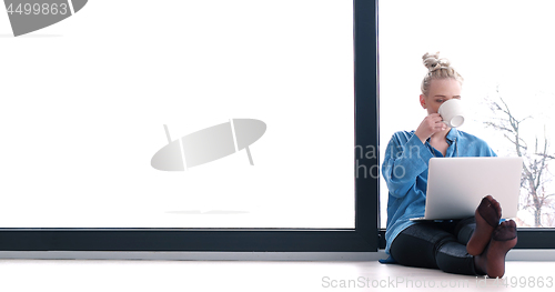 Image of young women using laptop computer on the floor