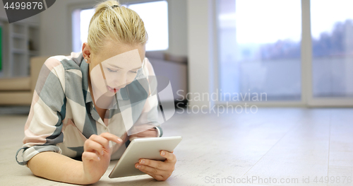 Image of young women using tablet computer on the floor