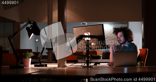 Image of man working on computer in dark office