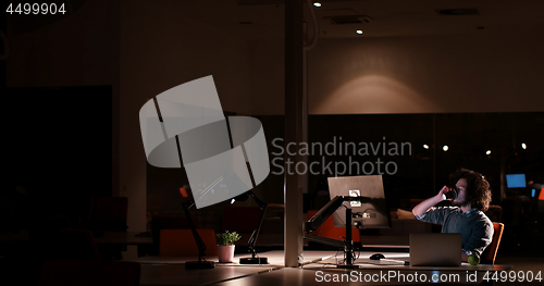 Image of man working on computer in dark office