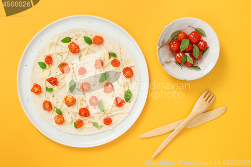 Image of Vegetarian tortilla and tomatoes on yellow background