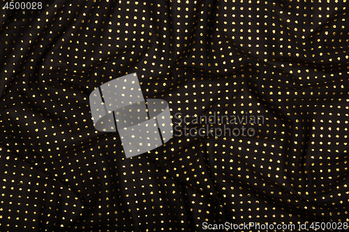 Image of Crumpled black fabric with golden metallic dots