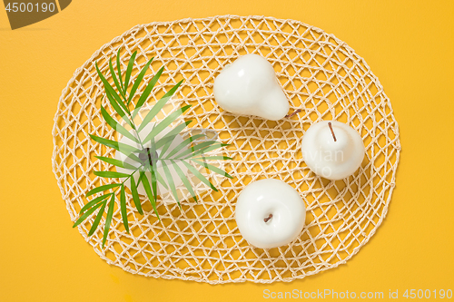 Image of Palm leaves in a vase and white decorative fruits