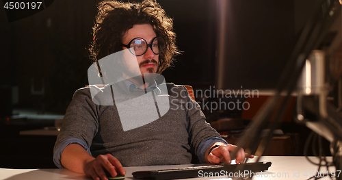 Image of man working on computer in dark office