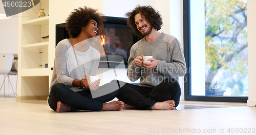 Image of multiethnic couple  in front of fireplace