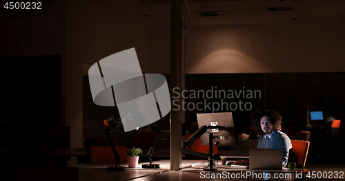 Image of man working on computer in dark office