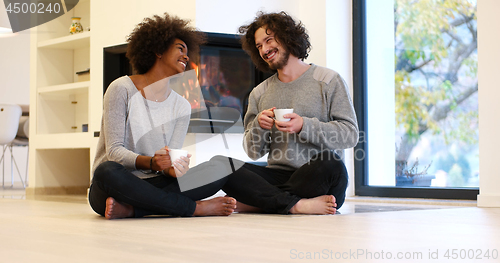 Image of multiethnic couple  in front of fireplace