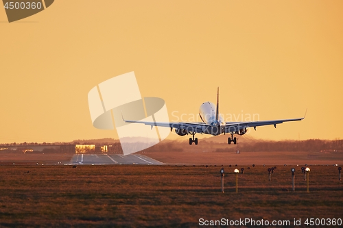 Image of Airplane landing at sunset