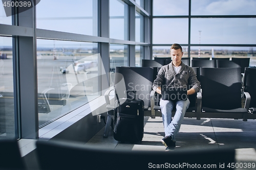 Image of Traveler using laptop in airport terminal