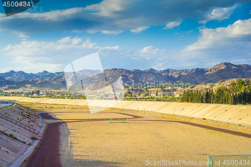 Image of A football field on the mountain s on tha background.