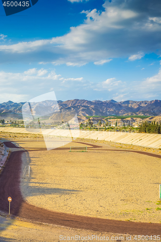 Image of A football field on the mountain s on tha background.