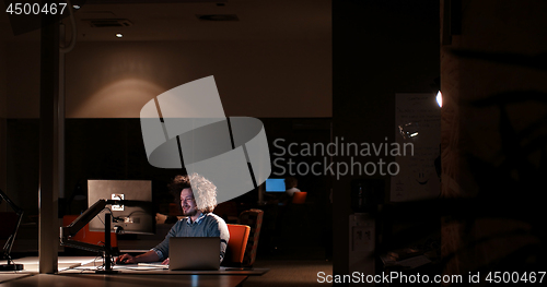 Image of man working on computer in dark office